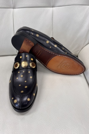 Black Leather Loafers With Gold Star Patterns and Bold Gold Accents